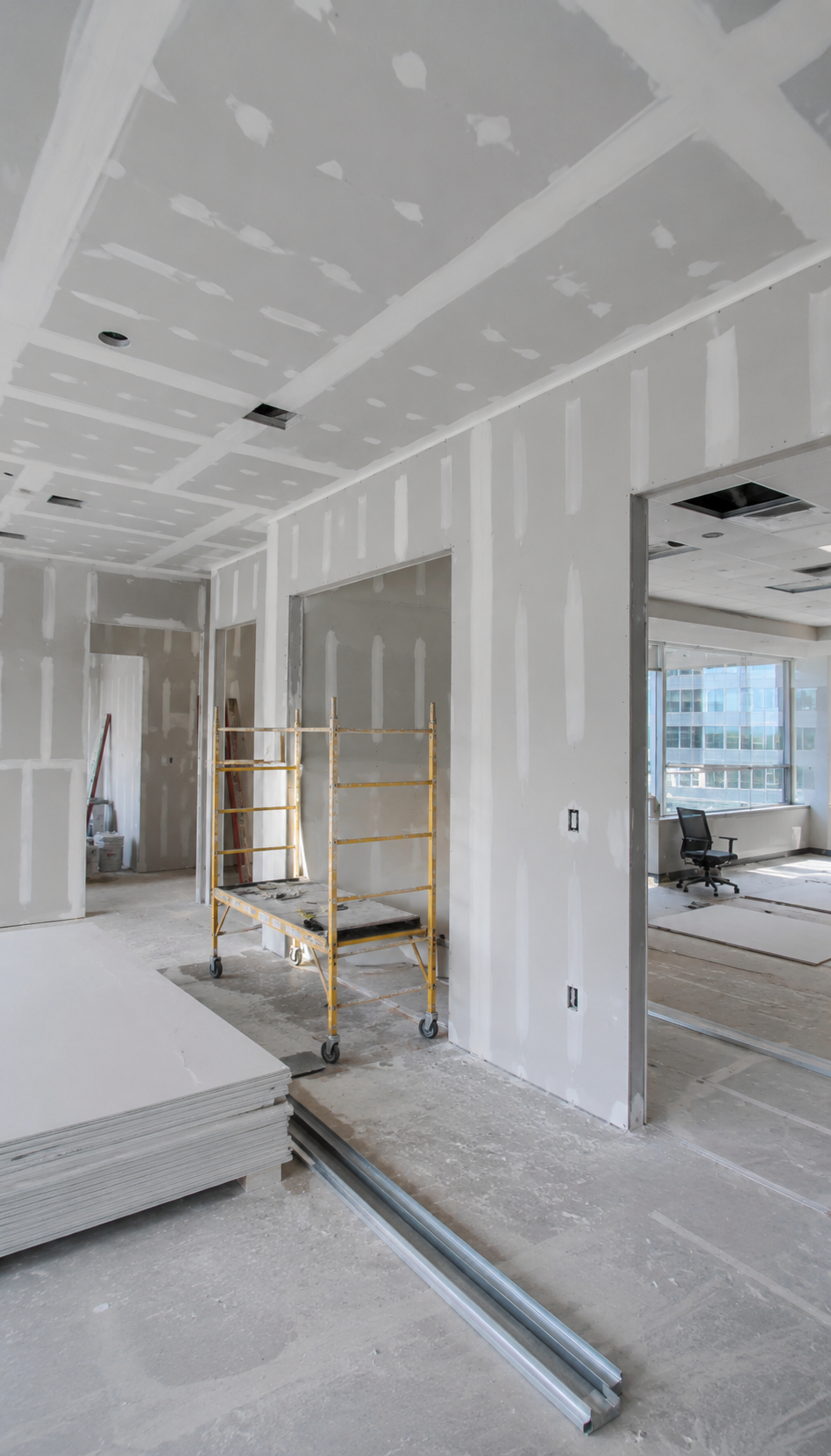 commercial office drywall installation in progress with unfinished walls and professional construction setup